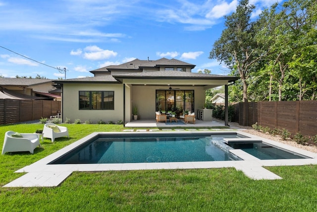 rear view of house featuring ceiling fan, a yard, a pool with hot tub, and a patio area