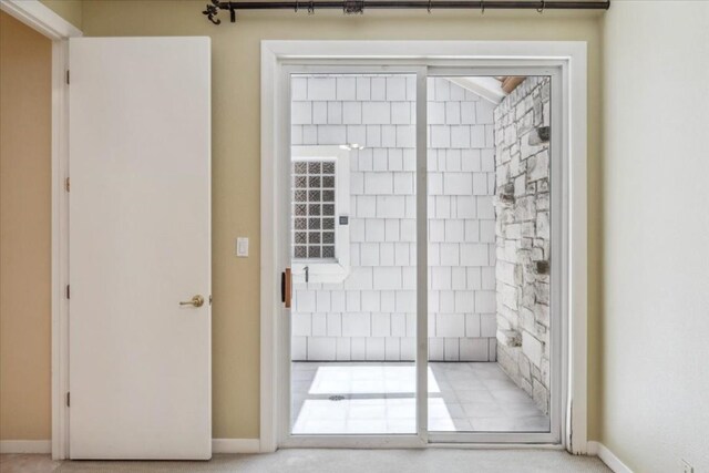 doorway to outside featuring carpet floors