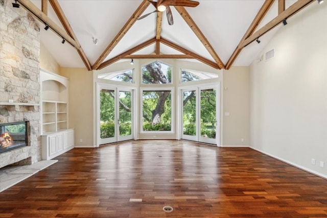 unfurnished living room with hardwood / wood-style flooring, a fireplace, beamed ceiling, and high vaulted ceiling