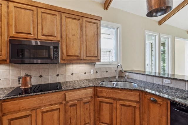 kitchen with backsplash, black appliances, sink, and dark stone countertops