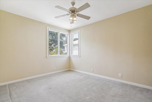 carpeted spare room with ceiling fan