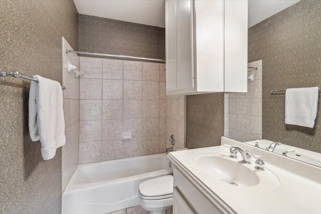 full bathroom featuring tile patterned floors, vanity, tiled shower / bath, and toilet