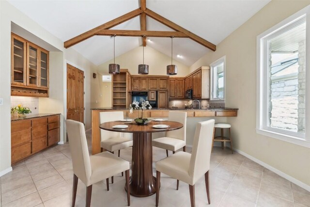 tiled dining space with sink and high vaulted ceiling