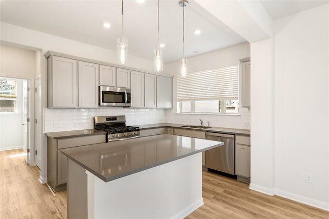 kitchen with appliances with stainless steel finishes, plenty of natural light, sink, and a center island