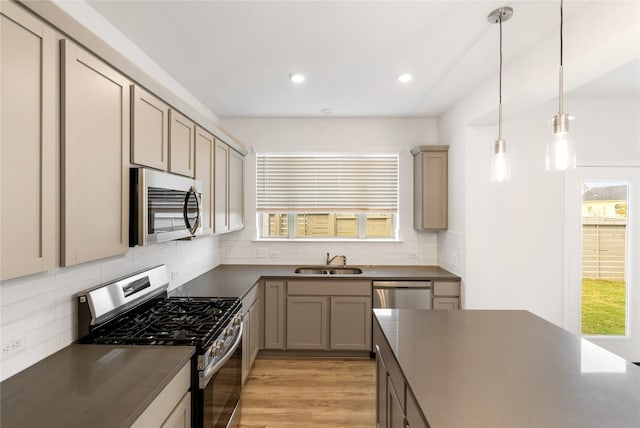 kitchen featuring light hardwood / wood-style flooring, decorative light fixtures, sink, stainless steel appliances, and backsplash