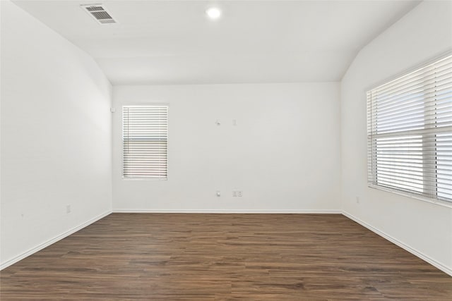 spare room featuring vaulted ceiling and dark wood-type flooring