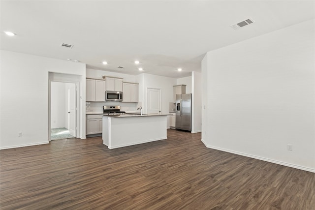 kitchen featuring sink, a center island with sink, dark hardwood / wood-style floors, and appliances with stainless steel finishes