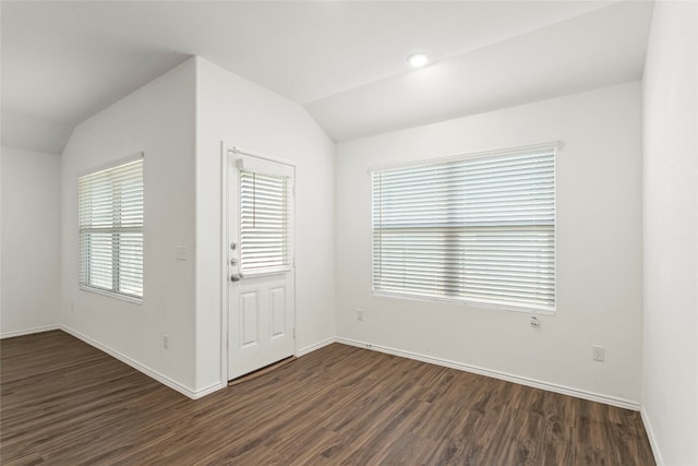 unfurnished room featuring dark hardwood / wood-style floors and vaulted ceiling