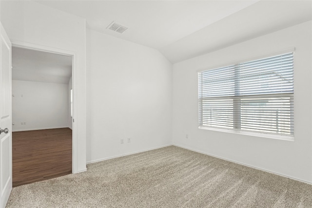 unfurnished room featuring hardwood / wood-style floors and lofted ceiling