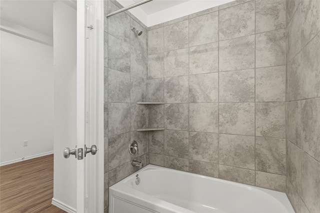 bathroom featuring wood-type flooring and tiled shower / bath