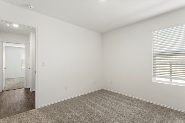 unfurnished room featuring dark colored carpet