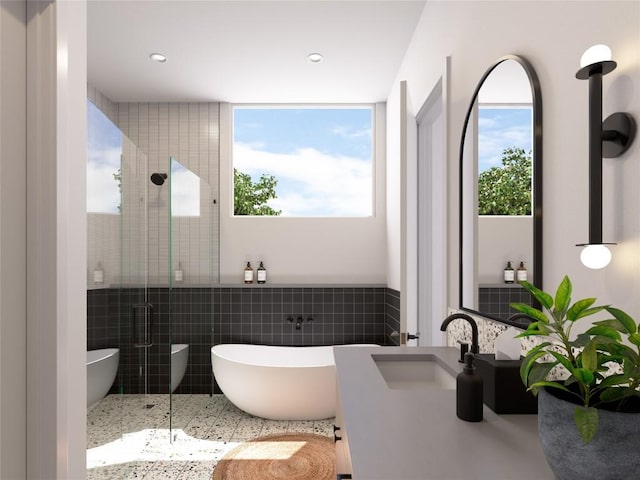 bathroom featuring a wealth of natural light, tile walls, vanity, and plus walk in shower