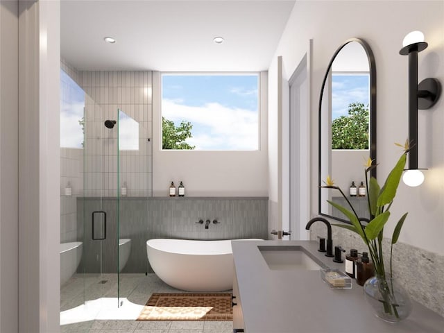 bathroom with shower with separate bathtub, a healthy amount of sunlight, and sink