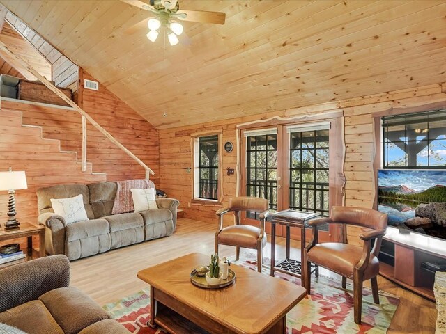 living room featuring wood ceiling, light hardwood / wood-style flooring, wooden walls, and ceiling fan