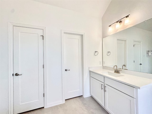 bathroom with vanity, lofted ceiling, and tile patterned floors