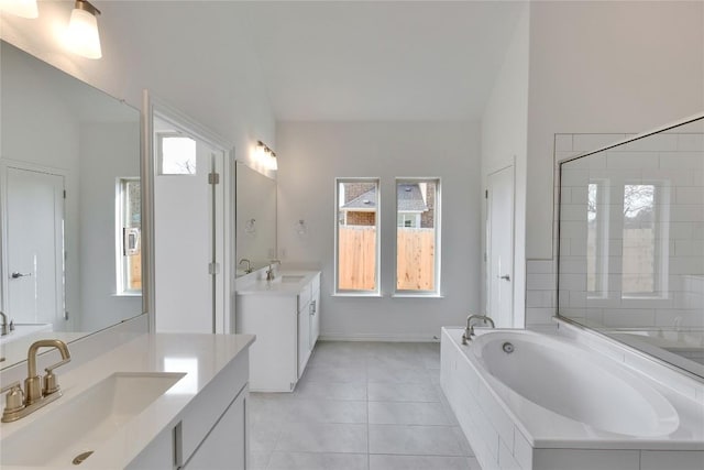 247 Du Bois Ln, Kyle, TX 78640 - full bath with tile patterned floors, two vanities, a garden tub, and a sink