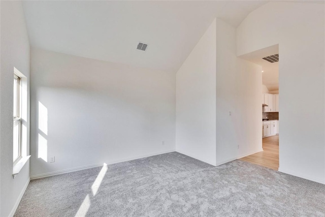 247 Du Bois Ln, Kyle, TX 78640 - empty room with visible vents, high vaulted ceiling, baseboards, and carpet floors