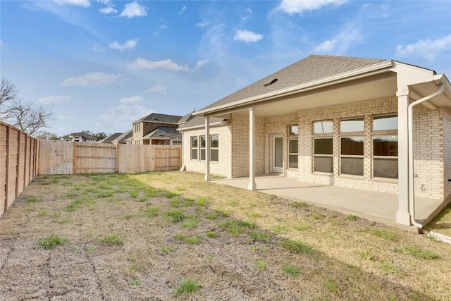 247 Du Bois Ln, Kyle, TX 78640 - rear view of house with a patio, a fenced backyard, brick siding, and a lawn