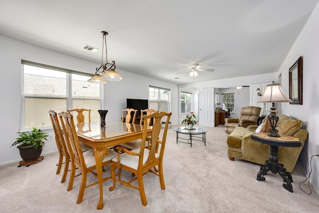 dining room featuring light carpet, ceiling fan, and plenty of natural light