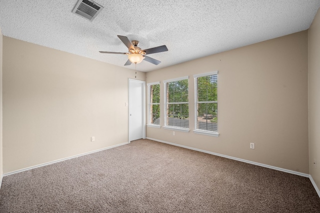 carpeted spare room featuring ceiling fan and a textured ceiling