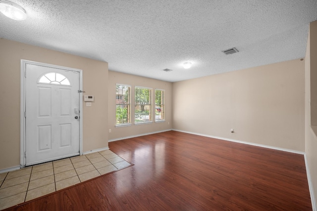 foyer with light hardwood / wood-style floors and a textured ceiling