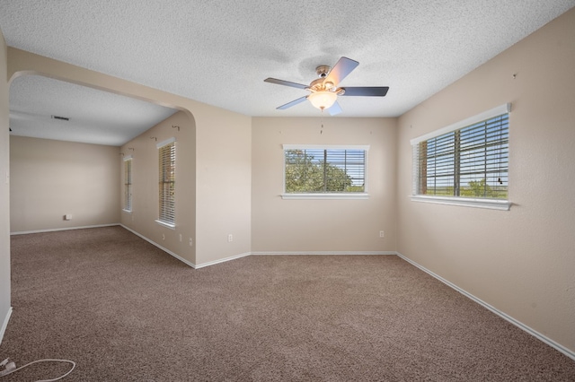 empty room with ceiling fan, carpet floors, and a textured ceiling