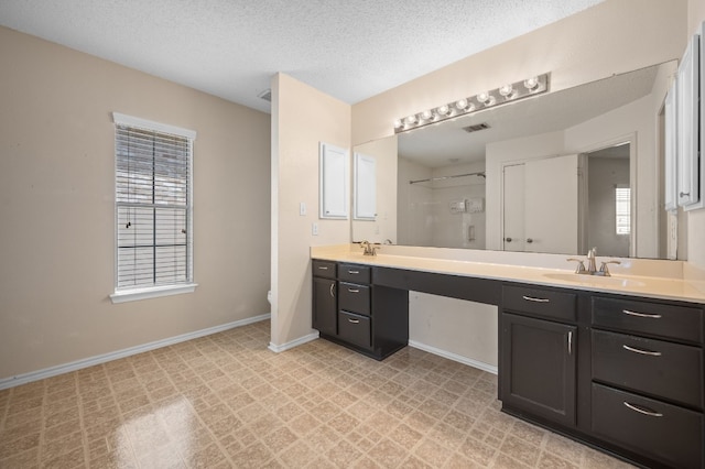 bathroom featuring vanity, plenty of natural light, toilet, and a textured ceiling