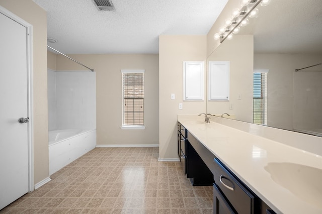 bathroom with shower / bath combination, vanity, and a textured ceiling