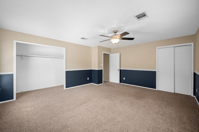 unfurnished bedroom with ceiling fan, a textured ceiling, and carpet flooring