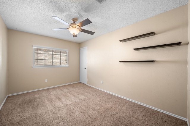 unfurnished room featuring ceiling fan, light colored carpet, and a textured ceiling