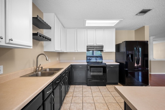 kitchen featuring light tile patterned floors, sink, white cabinetry, and black appliances