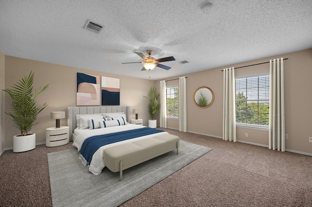 carpeted bedroom with ceiling fan, a textured ceiling, and multiple windows