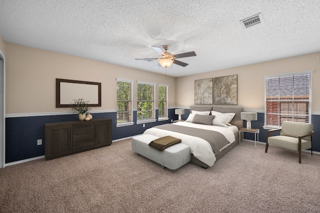 carpeted bedroom with a textured ceiling and ceiling fan