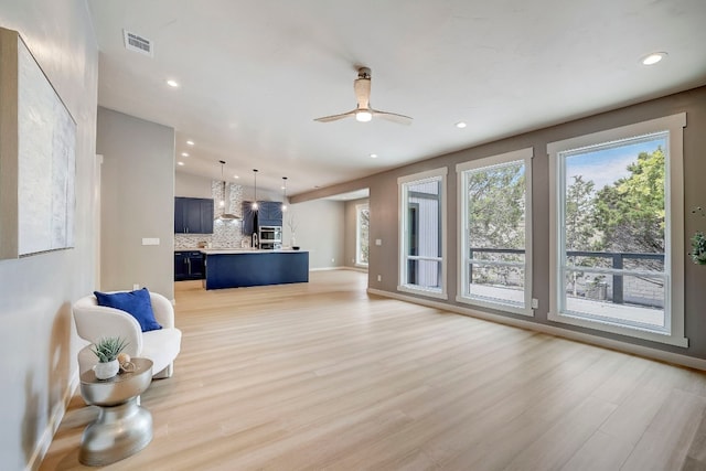 living room featuring lofted ceiling, light wood-type flooring, and ceiling fan