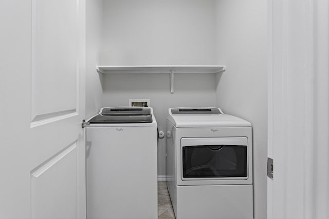 laundry area with washer and clothes dryer and light tile patterned flooring