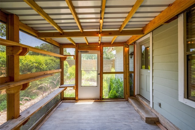 unfurnished sunroom with beamed ceiling