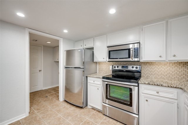 kitchen with light stone counters, backsplash, stainless steel appliances, and white cabinets