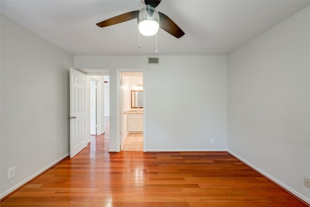 unfurnished bedroom featuring light hardwood / wood-style flooring, ceiling fan, and ensuite bathroom