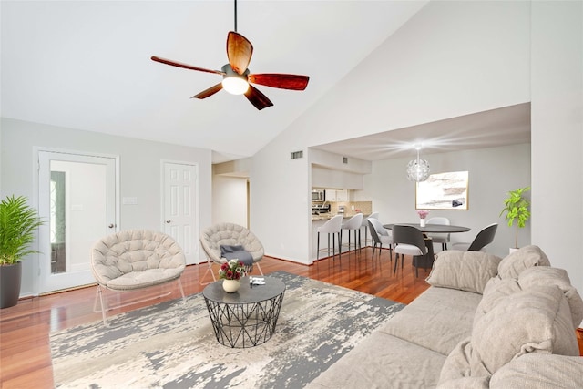 living room with hardwood / wood-style flooring, ceiling fan, and high vaulted ceiling