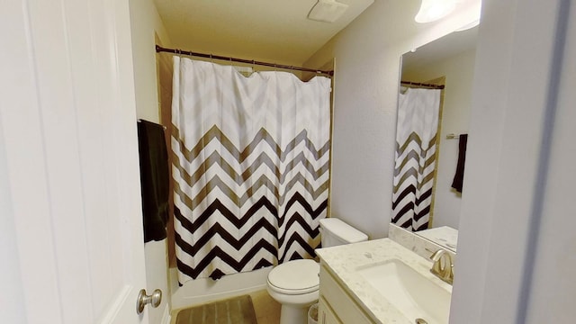 bathroom featuring vanity, toilet, and curtained shower