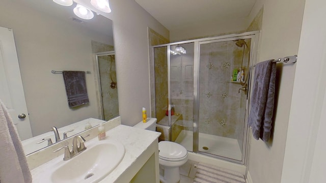 bathroom with tile patterned flooring, toilet, a shower with door, and vanity