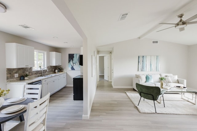 kitchen featuring tasteful backsplash, vaulted ceiling with beams, ceiling fan, white cabinets, and light hardwood / wood-style flooring