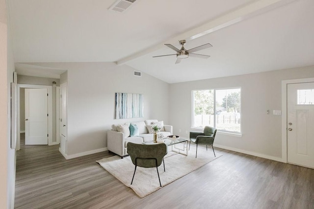 living room with ceiling fan, hardwood / wood-style floors, and vaulted ceiling with beams