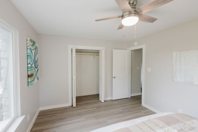 unfurnished bedroom with a closet, light wood-type flooring, and ceiling fan