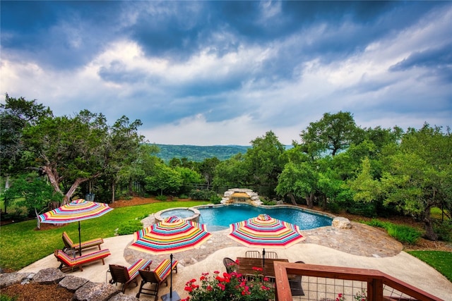 view of pool featuring a patio area and an in ground hot tub