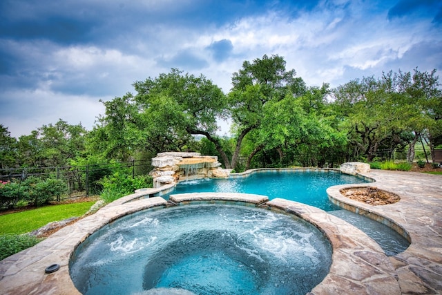 view of swimming pool with an in ground hot tub and pool water feature