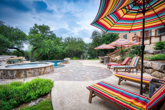 view of pool featuring an in ground hot tub and a patio