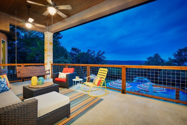 patio terrace at dusk featuring an outdoor living space, a balcony, and ceiling fan