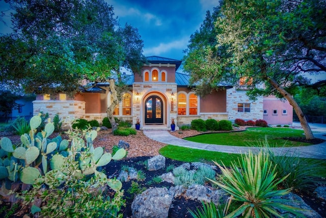 7610 Ramble Rdg, San Antonio, TX 78266 - mediterranean / spanish-style house with stone siding, a standing seam roof, stucco siding, french doors, and a metal roof