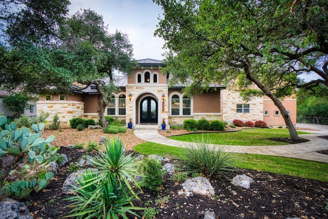 mediterranean / spanish-style home with a front lawn